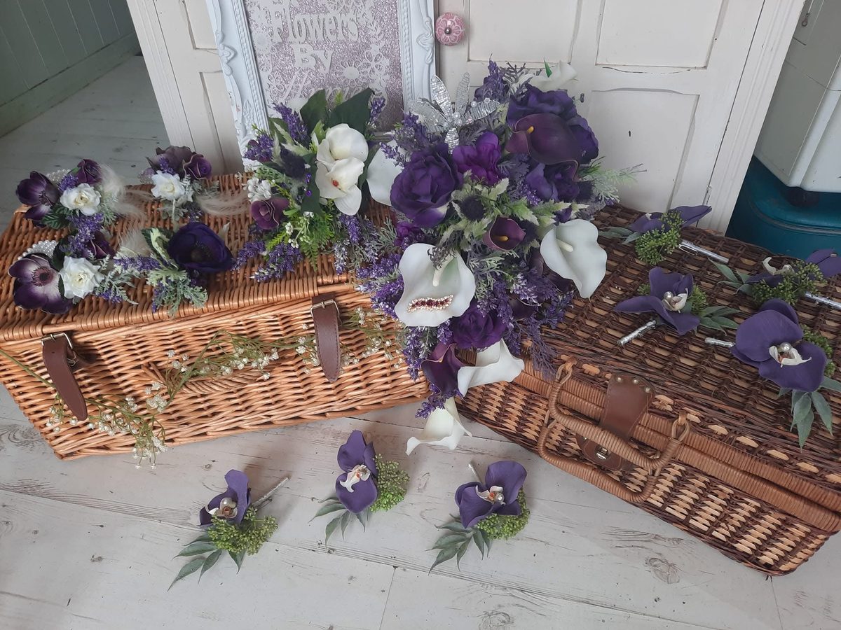 A purple and ivory bridal bouquet with matching buttonholes