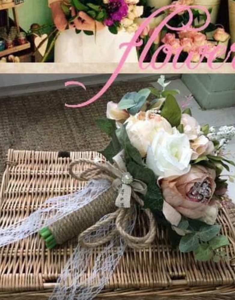 A rustic bridal bouquet of ivory roses tied with hessian and lace