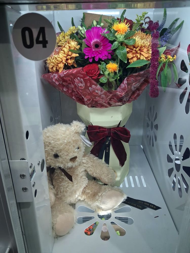 A bright autumn bouquet in a gift box with a velvet bow and a teddy bear