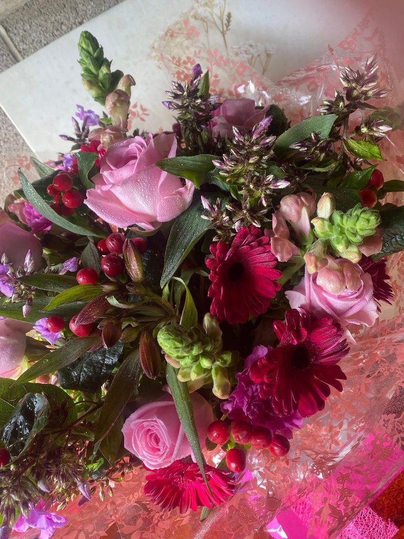Pink roses, burgundy gerberas and berries in a gift bouquet