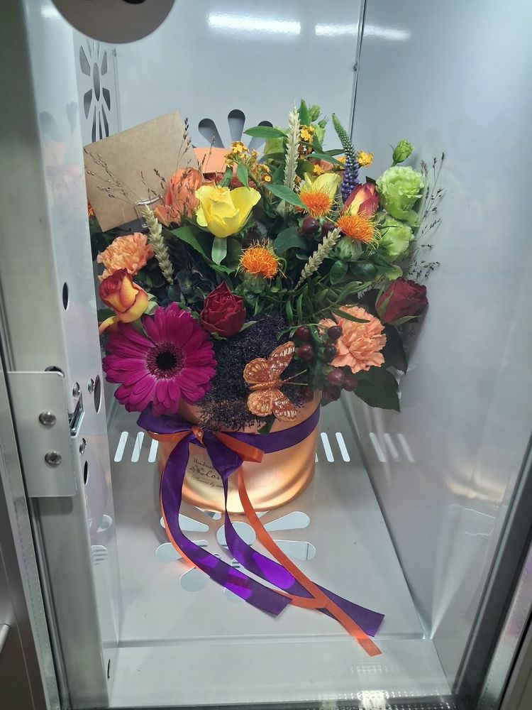 Roses, gerberas and carnations in a copper hat box with purple and orange ribbon