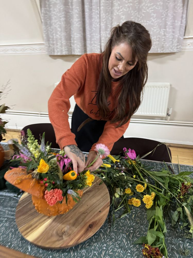 Annie showing the group how to build their arrangement
